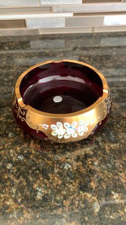 vintage Bohemian Czech cranberry red glass ashtray with hand-painted gold trim and raised floral enamel decorations.
