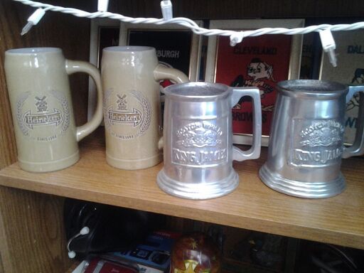 Two sets of beer steins one Heineken ceramic one silver king james no chips or damage