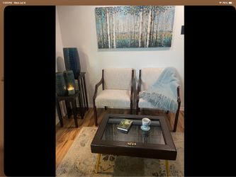 A pair of sitting chairs and a one of a kind table.