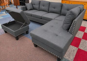 Brand new grey linen Sectional Sofa with storage ottoman and 2 accent pillows and cup holders.