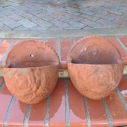 A pair of rustic Mexican wall hanging rustic clay pots