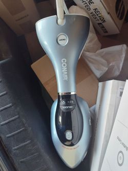 Powerful handheld garment steamer by Conair in a light blue and black color scheme. This unit has a large steam head with multiple vents for even dist