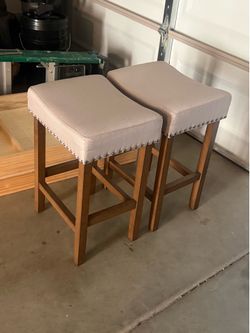 2 upholstered saddle-seat counter stools