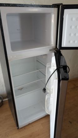 The small refrigerator and freezer is in good condition.