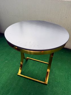 Mesa auxiliar redonda moderna con detalles dorados