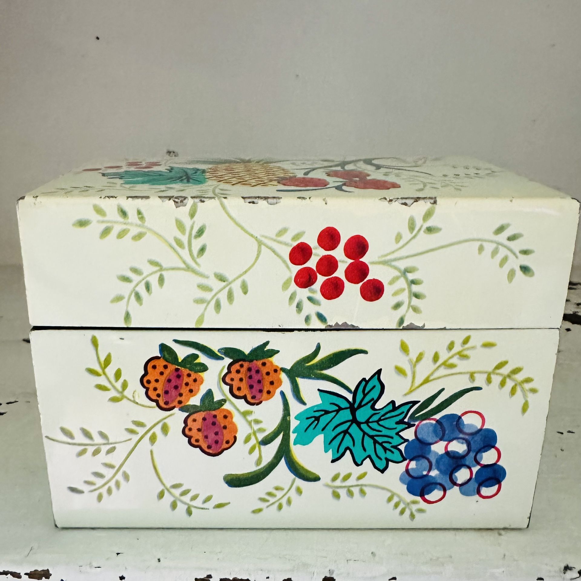 Vintage metal fruit design recipe box filled with old recipe cards. Some of the recipes are handwritten some are cut out from magazines etc.