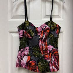 This elegant black corset top by Trina Turk features a bustier style with a structured bodice and fitted seaming details. The sleeveless design and ca