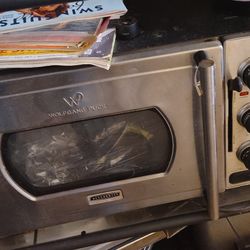 The image displays a Wolfgang Puck KitchenTek Pressure Oven, a countertop appliance that combines conventional oven functions with pressure cooking te