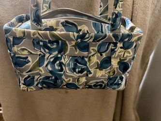 a gray and blue floral woven seatbelt handbag by Harveys featuring dual top handles and a zippered top.