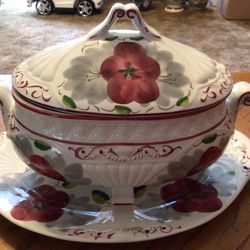 A vintage large 10" wide Chinouserie decorative multi colored floral bowl of pinks, yellow, green and purple. It has a blue background and a gold rim.