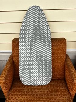 Small portable ironing board hangs in closet also