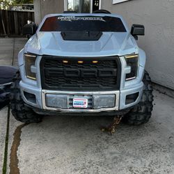 Power Wheels Ford F150 Raptor Battery-Powered Ride-On Vehicle with Music Sounds & Microphone, 12V