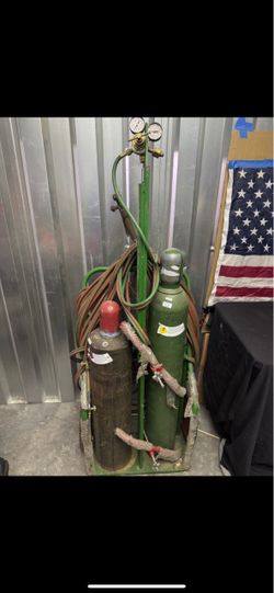 $199 portable oxy-acetylene welding and cutting torch kit, featuring both oxygen and acetylene cylinders mounted on a metal cart or trade for battery