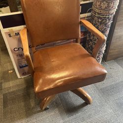 Vintage leather and wood office chair on wheels