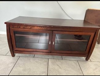 solid wood TV stand with clear glass doors.
