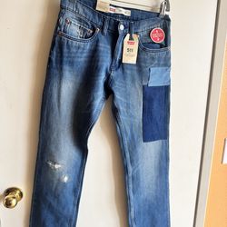 Classic slim-straight silhouette from Levi's. Medium blue denim with contrasting patch detail on the thigh. Subtle distressing adds character. Five-po