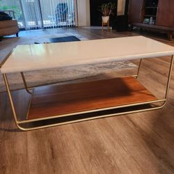 mid-century coffee table (white top, gold metal frame, wood lower shelf)