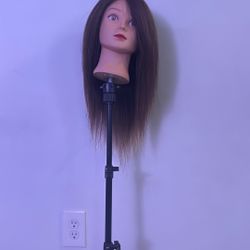 hairdresser mannequin head mounted on a tripod stand.