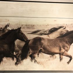 Painted galloping horses on wooden plank board