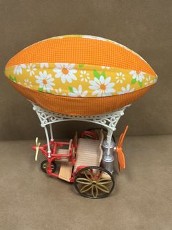 Calico Critters (or Sylvanian Families) Sky Ride Adventure hot air balloon toy vehicle.   It features a vehicle with spinning tires and propellers. To