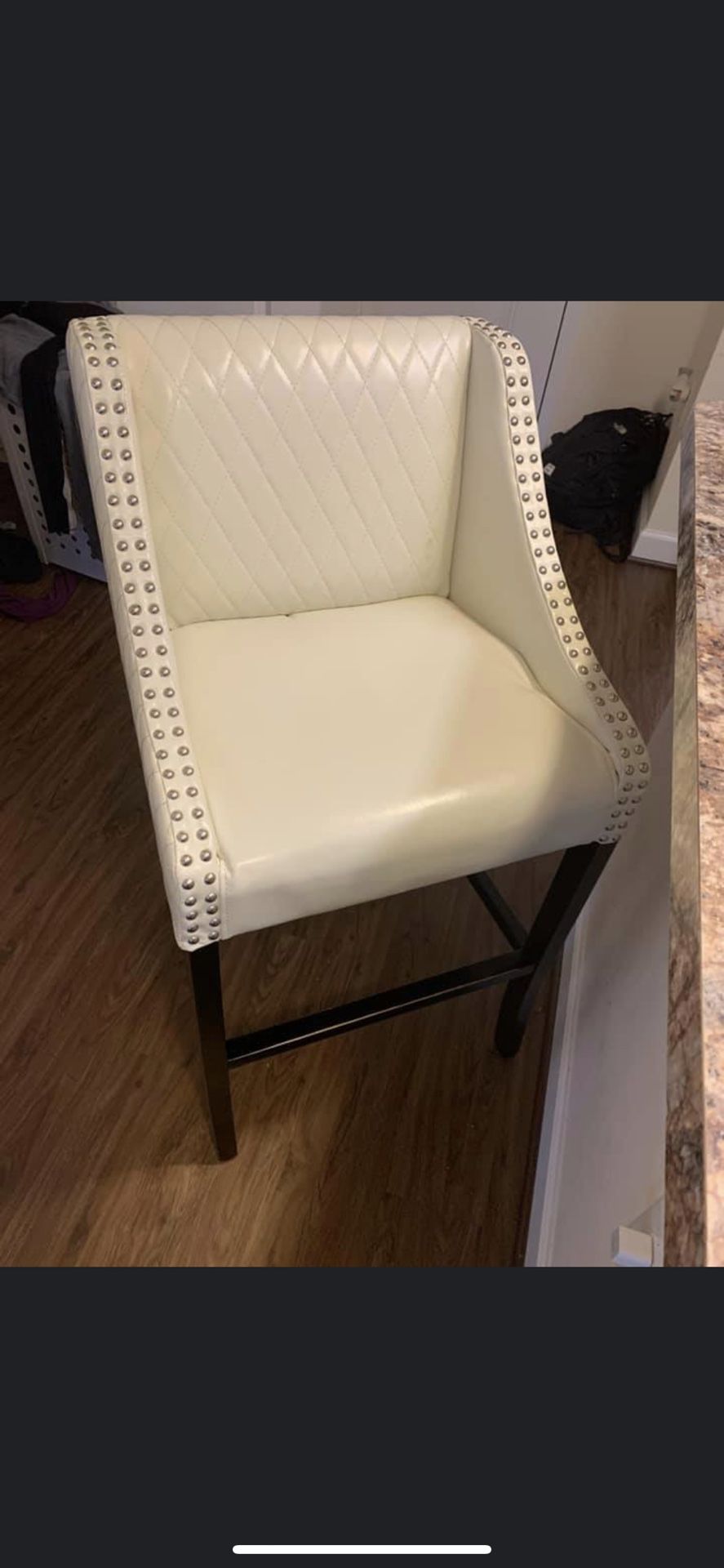 Two cream color bar stool chairs. Used the paint is coming off the foot rest a little line