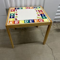 wooden kids' activity table with a colorful alphabet and number graphic top