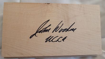 Piece of the basketball floor autographed by UCLA Coach John Wooden