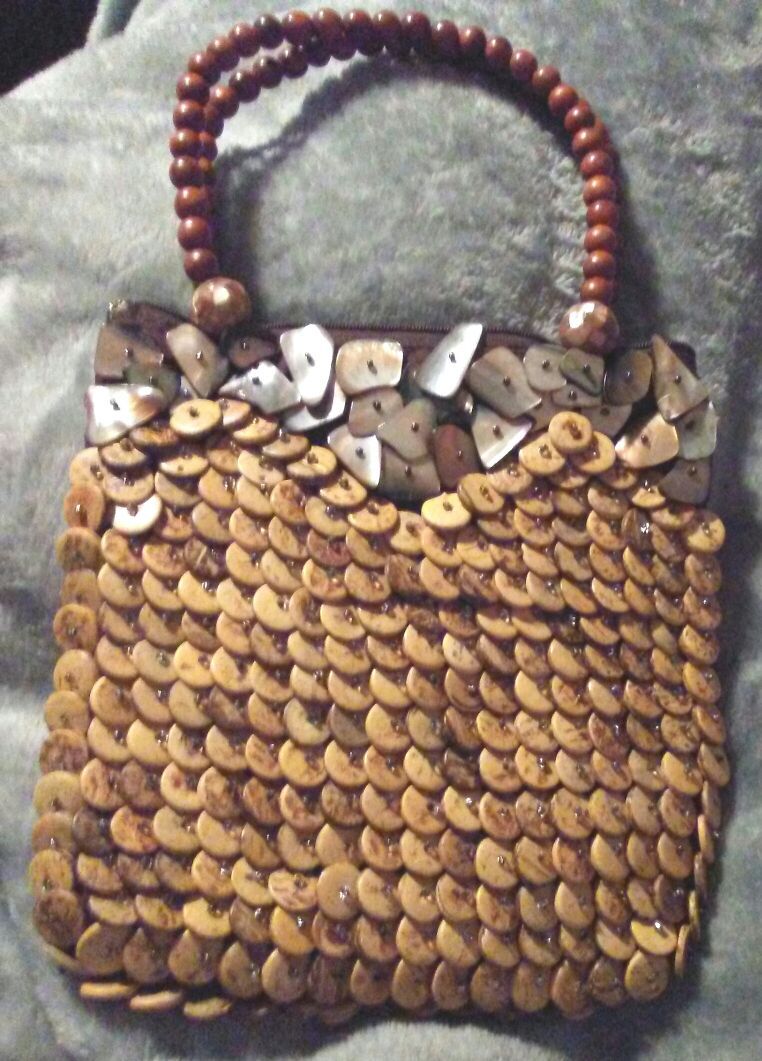 Decorative purse. Wooden buttons cover it. Handle is made of wooden beads. Very pretty.