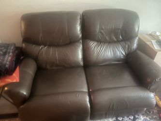 Brown leather love seat legs go up