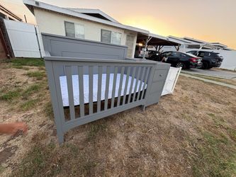 Gray Baby Crib with Attached Dresser
