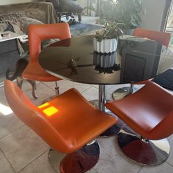 Modern Black Glass Table With Adjustable Orange Chairs