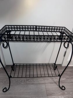 Elegant black metal 2-tier shelf with decorative design. Perfect for bathroom, kitchen, or entryway use.