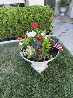 Elegant garden planter with a variety of colorful flowers and a small American flag.