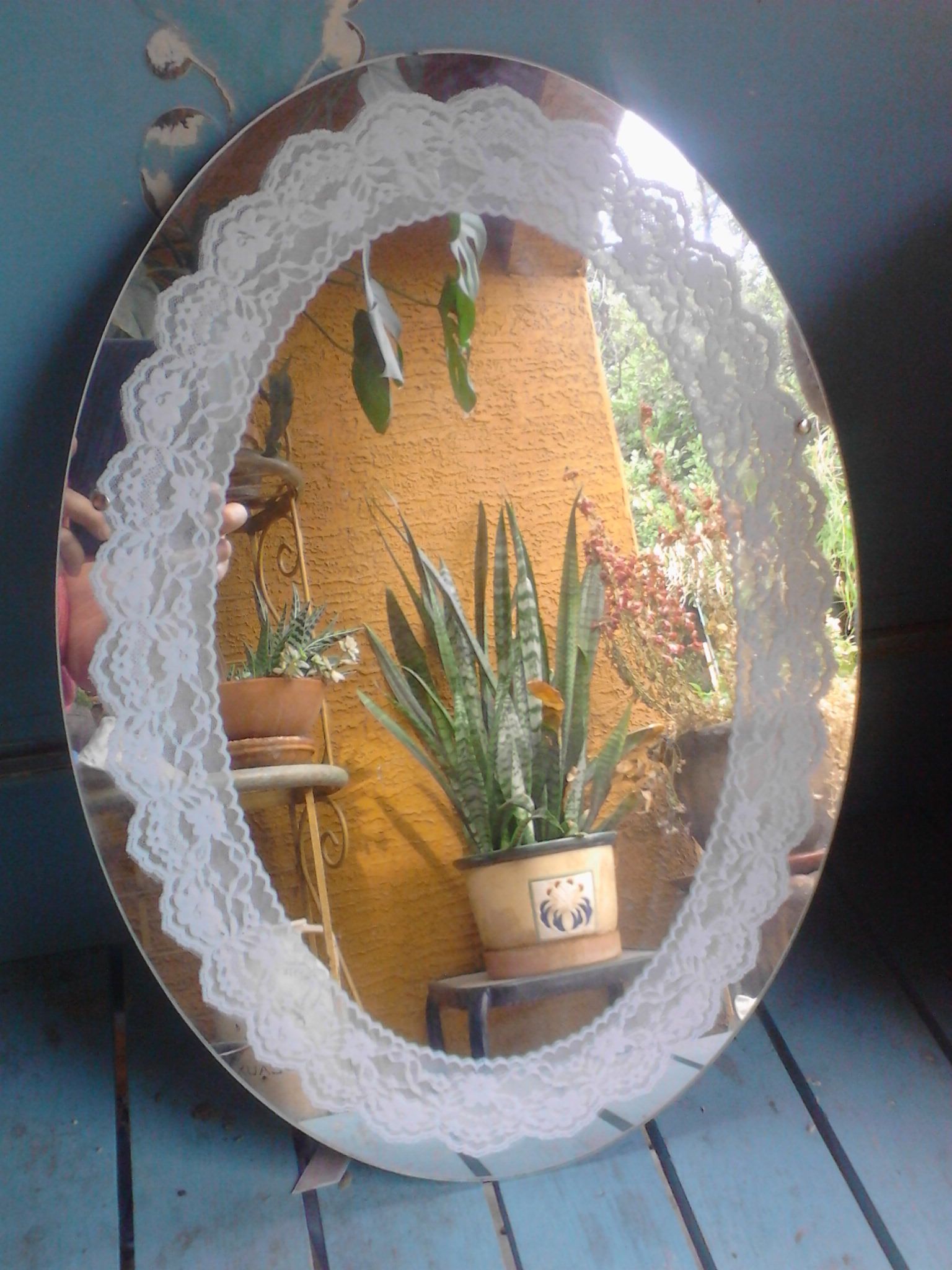 Oval mirror with lace stenciled design around the edge