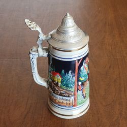 Vintage West Germany beer stein Die Fischerin v. Bodensee with pewter 
lid and handle.   (The Fisherwoman of Lake Constance). It is decorated 
with co