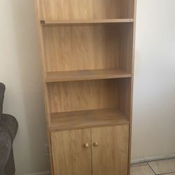 A Light Brown Shelf with Cabinets On The Bottom