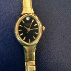 Elegant Gold Watch With A Black Dial.