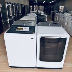 New Samsung 5.1 cu. ft. Smart Top Load Washer with ActiveWave Agitator and matching 7.4 cu. ft. Gas Dryer with Steam Sanitize+ in white.