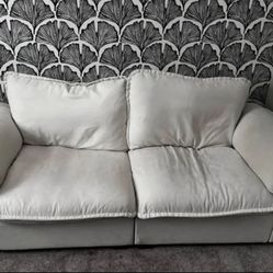 Off white colored loveseat sofa