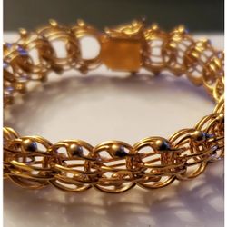 Vintage, yellow gold-filled (marked 1/20 12K G.F.)Charm bracelet. The bracelet features several curved intertwined links 