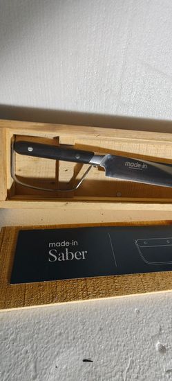 Made In champagne saber with an ebony wood handle.