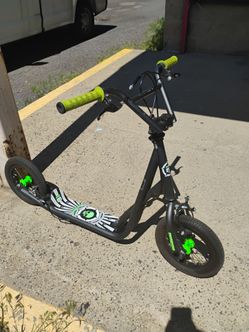 Mongoose Expo kick scooter in black with neon green accents and a skull-graphic dec