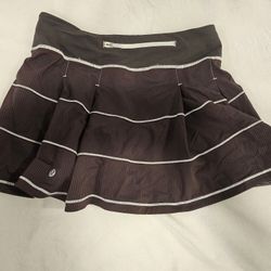 Lululemon Pace Rival skirt in a dark brown color with white pinstripes. 