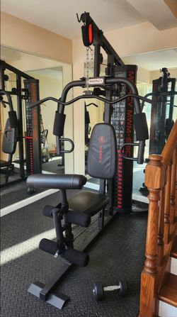 FITNESS Multi-station home gym with lat pulldown bar, adjustable weight stack, padded seat and back rest, leg developer, and low pulley cable system. 