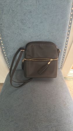 Black shoulder purse with front zipper pocket and tassel