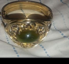 Whiting and Davis gold metal cuff bracelet signed with a center green tiger eye glass cabochon