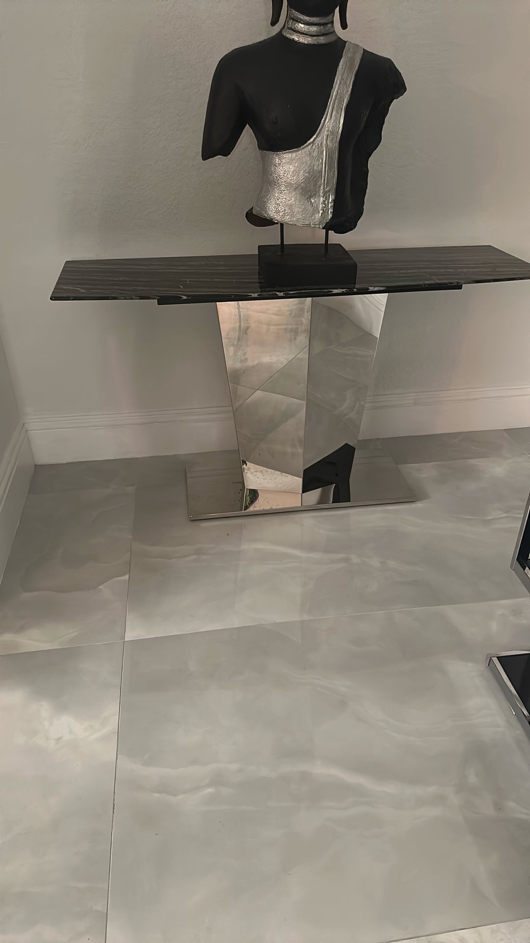 2 console table with a black and white marble top and a polished stainless steel base