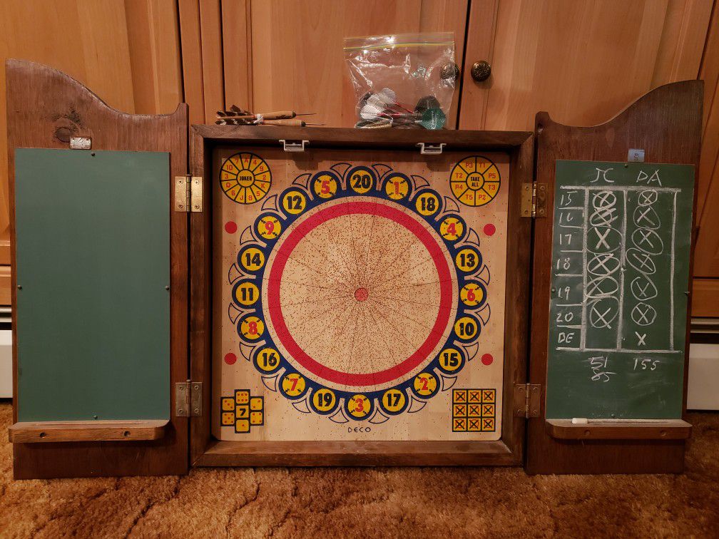 Cork, two sided dart board with wood cabinet. Traditional game on one side, baseball game on reverse side.
