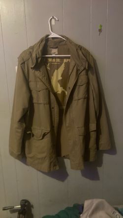 olive-green military-style utility jacket with a large winged horse graphic and star symbol