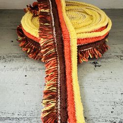 Vintage looped fringe trim. Great retro colors. orange, brown and yellow. 24 feet 7” long. A little over eight yards. One continuous piece of trim.